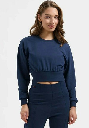 Navy blue cropped sweatshirt with long sleeves, ribbed hem, and smooth cotton texture. Paired with matching high-waisted pants.