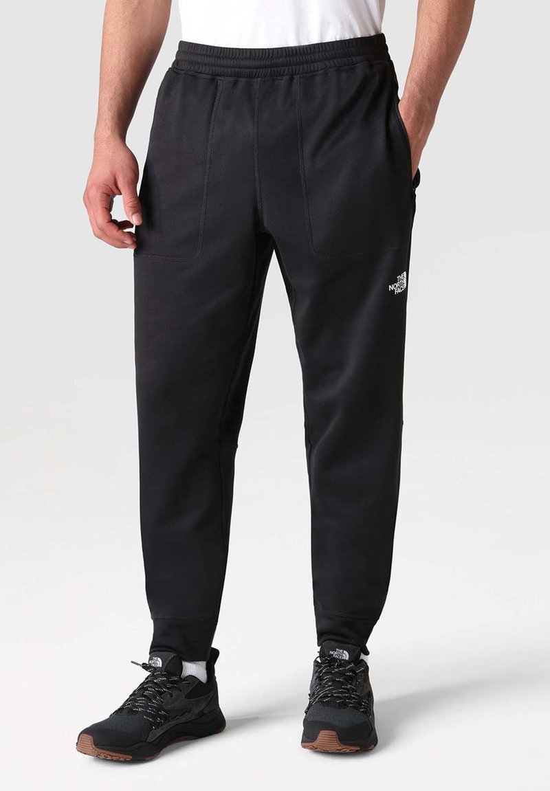 Czarne spodnie sportowe z elastycznym pasem, z dwiema przednimi kieszeniami i małym białym logo na lewym udzie. Teksturowana tkanina.