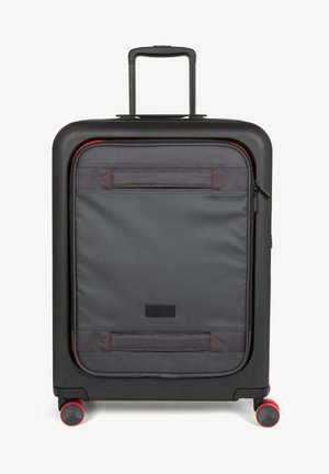 Zwarte harde koffer met een grijze stoffen voorzak, rode ritsaccenten en vier rode wielen; beschikt over een uitschuifbare handgreep.