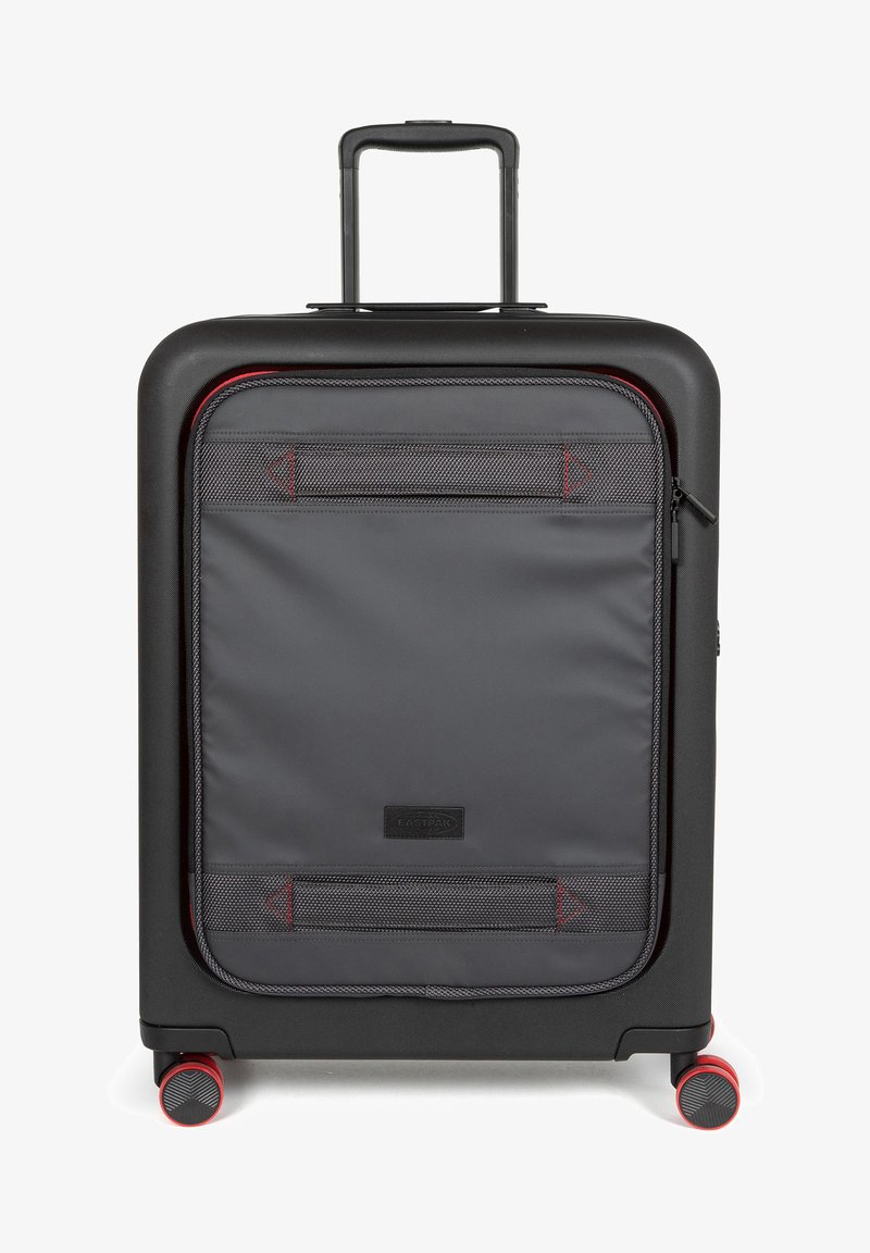 Zwarte harde koffer met een grijze stoffen voorzak, rode ritsaccenten en vier rode wielen; beschikt over een uitschuifbare handgreep.