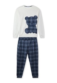 Bawełniany zestaw piżamowy składający się z białej bluzki z długim rękawem z grafiką granatowego misia oraz granatowych spodni w kratę z elastycznym paskiem.