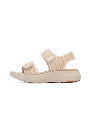 Sandalias beige con una parte superior de malla transpirable, correas ajustables de velcro y una suela exterior de cuña ligera y texturizada.