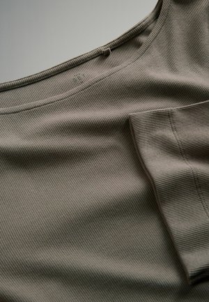 Prążkowany zielono-brązowy materiał z okrągłym dekoltem i kieszenią po boku. Charakteryzuje się subtelnym wzorem tekstury na całej powierzchni materiału.