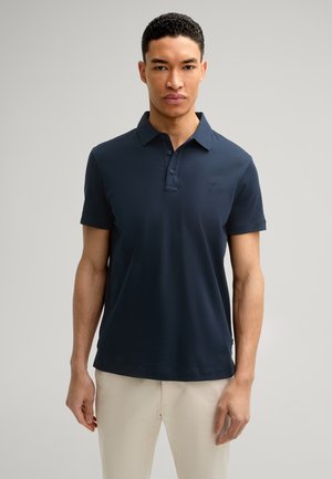 Dunkelblaues Poloshirt aus weichem Stoff, mit einem Kragen, kurzen Ärmeln und einem dezenten gestickten Logo auf der Brust.