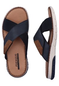 Sandales à brides croisées bleu marine avec un dessus texturé, semelle intérieure tan et semelle en caoutchouc blanche. Présente la marque RIEKER sur la semelle.