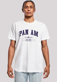 Weißes Baumwoll-T-Shirt mit violettem Schriftzug "PAN AM" und einem Flugzeug-Graphic sowie "EST. 1927" darunter. Lässige Passform mit kurzen Ärmeln.