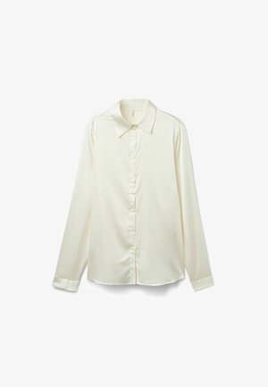 Blouse à manches longues de couleur crème, en tissu satiné. Présente un col classique, une patte de boutonnage et un ourlet légèrement arrondi en bas.
