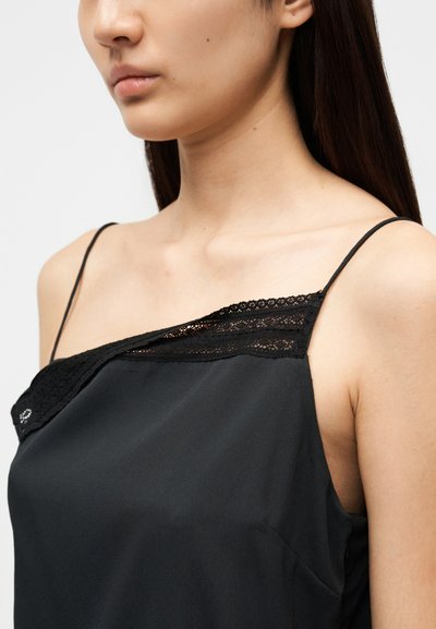 Μαύρο καμιζόλη με διακοσμητικά δαντέλας στη γραμμή του ντεκολτέ, με λεπτές τιράντες στους ώμους και απαλό, ελαφρύ ύφασμα.