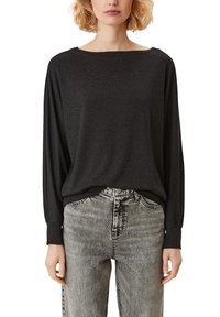 Svart långärmad topp i ett mjukt, texturerat tyg med båthals och avslappnad passform, i kombination med blekta grå jeans.