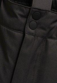 Black fabric with subtle herringbone pattern, featuring two round black buttons and visible stitching along the seam.