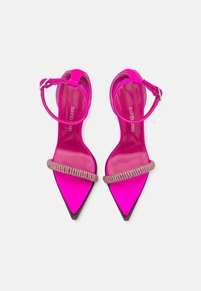 Sandalias de tacón stiletto rosa neón con punta afilada, que cuentan con una correa metálica adornada con joyas en la parte frontal y una correa ajustable en el tobillo.