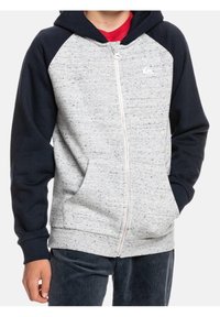 Šedá a námořnická modrá mikina s kapucí na zip s jemně drcenou texturou, obsahující klokanní kapsu a logo na hrudi. Materiál z bavlněné směsi.