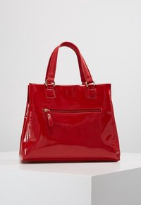Borsetta in pelle verniciata rossa con finitura lucida, forma rettangolare, doppie maniglie corte e tasca frontale con zip per una funzionalità aggiuntiva.