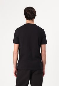 Zwarte katoenen t-shirt met korte mouwen, ronde hals en een standaard pasvorm. Soepele textuur zonder zichtbare patronen of accenten.