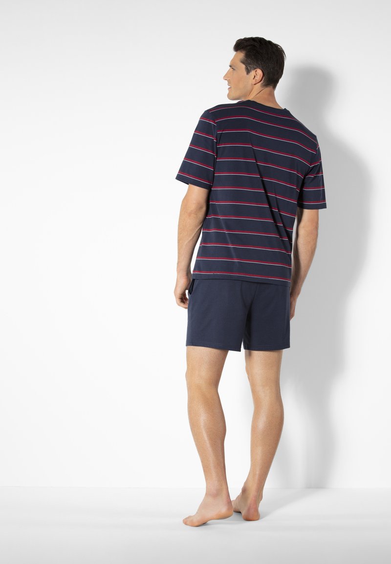Navy striped t-shirt with red lines, short sleeves, and a round neck paired with navy shorts, shown from the back. Barefoot on a white background.