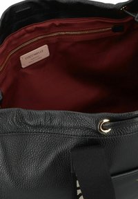 Sac à main en cuir noir avec un extérieur texturé, doublure en tissu rouge, quincaillerie dorée et une poche zippée. Présente une étiquette de marque à l'intérieur.