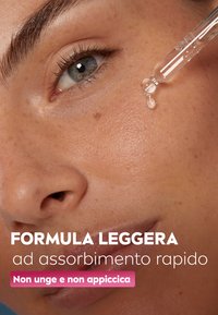 Primo piano di un contagocce di siero per la pelle vicino a una pelle liscia, che mostra un finish luminoso. Il testo evidenzia una formula leggera ad assorbimento rapido.