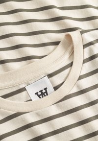Tricou din bumbac cu bază crem și dungi orizontale verzi măslinii. Are guler rotund și un eticheta vizibilă cu logo. Textură netedă.