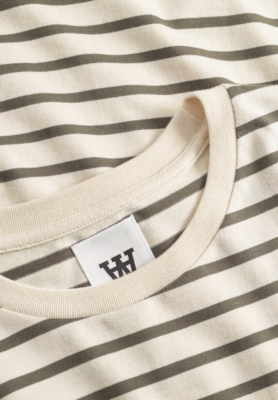 Cotton t-shirt with cream base and olive green horizontal stripes. Features a round neck and a visible label with logo. Smooth texture.