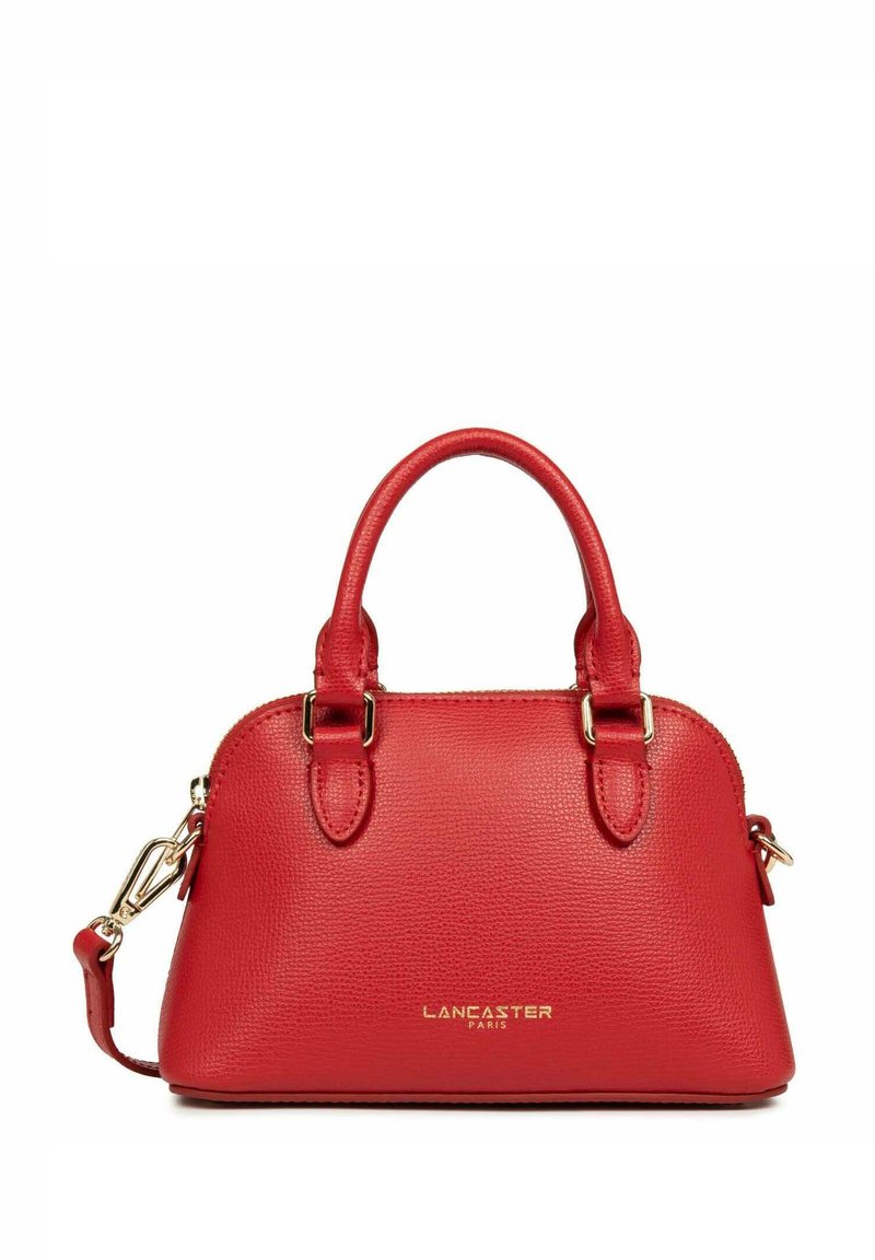 Sac à main en cuir rouge avec surface texturée, doubles poignées, bandoulière amovible et logo doré. Design arrondi et fermeture éclair.