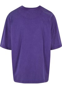 Lila bomulls t-shirt med avslappnad passform, korta ärmar, rundad halsringning och mjuk textur. Sömdetalj längs axlarna och nederkanten.