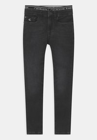 Pantalones vaqueros negros de denim con corte ajustado, que presentan una cinturilla con el logo "CALVIN KLEIN JEANS", bolsillos frontales y un diseño clásico.