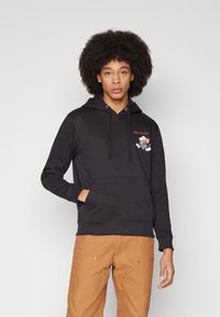 Fekete kapucnis pulóver, amely pamutból készült, elöl zsebbel és állítható húzózsinórral rendelkezik. A mellkasán hímezett mintázattal és színekkel díszített.