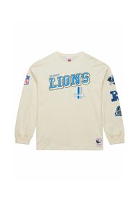 Cream long-sleeve T-shirt with "Detroit Lions" in blue lettering. Features team logos on sleeves and a patch at the bottom. Cotton material.