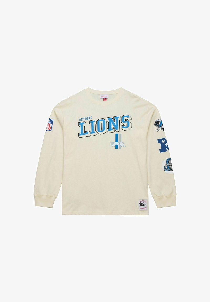 Cream long-sleeve T-shirt with "Detroit Lions" in blue lettering. Features team logos on sleeves and a patch at the bottom. Cotton material.