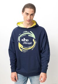 Marineblaue Hoodie mit gelbem Innenfutter, ausgestattet mit einem grafischen Design in Grün und Gelb. Das Material ist weich und hat eine Vordertasche.