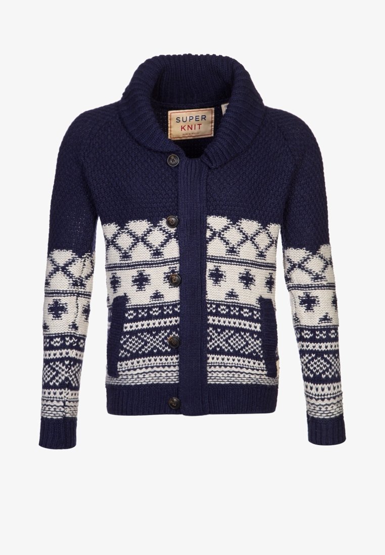 Dunkelblaues Strickjäckchen mit einem Schalkragen, das weiße geometrische Muster und fünf schwarze Knöpfe auf der Vorderseite aufweist. Figurbetontes Design.