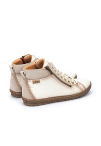 Botas de tobillo de cuero beige con acentos de ante, cremallera lateral y diseño de cordones. Punta redondeada y suela exterior de goma texturizada.