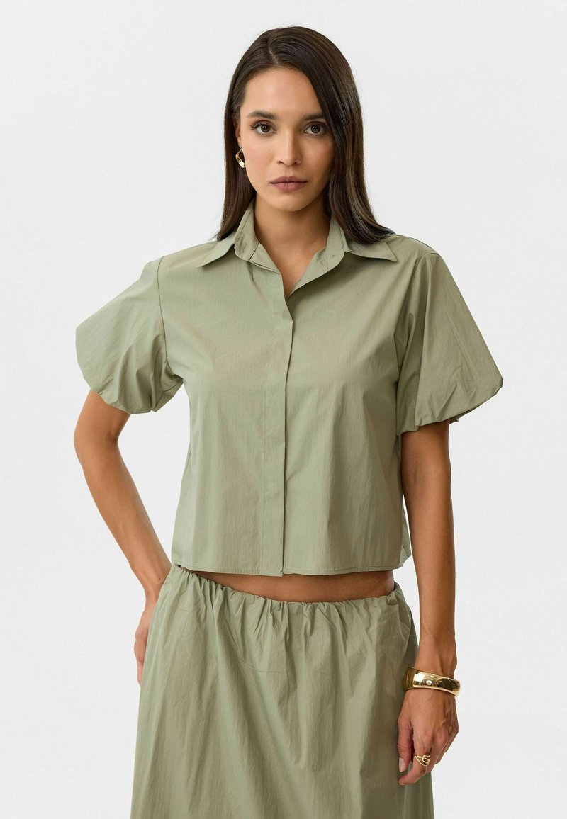 Korte mouwen, lichtgroene crop shirt met een knoopsluiting aan de voorkant, kraagontwerp en textuurfabricage, gecombineerd met een bijpassende geraffineerde rok.