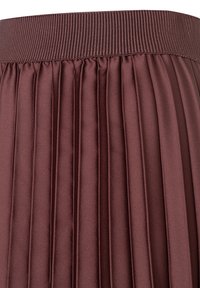 Burgunderfarbene, plissierte Rock mit einem breiten, strukturierten Gummibund und glattem, glänzendem Stoff mit gleichmäßigen Falten.