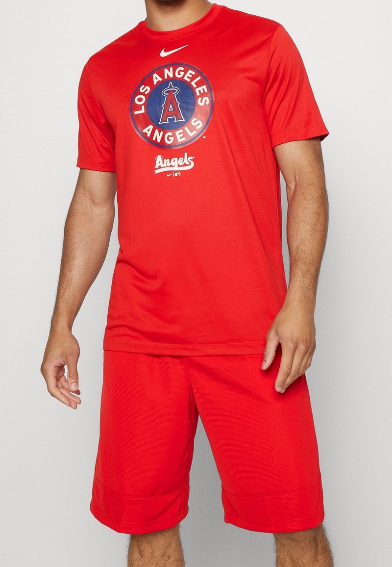 Conjunto atlético rojo que incluye una camiseta de manga corta con el logo de "Los Angeles Angels" y pantalones cortos a juego, fabricado en un tejido transpirable.
