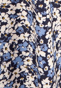 Tessuto floreale con sfondo navy, fiori bianchi e azzurri, con centri gialli, superficie texture.
