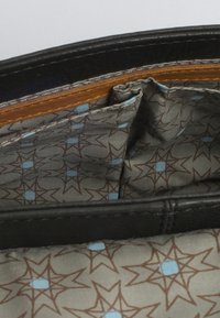 Interno di un portafoglio in pelle nera con rivestimento in tessuto grigio e un motivo a stelle con accenti marroni e blu, diverse fessure per carte e scomparti.