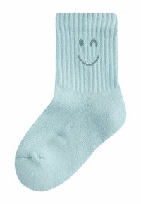 Helehall sinine soonik-sukk, millel on hallis naeratava näo kujundus. Sile tekstuur, pehme elastse kantiga ja ümar varbaküüs.