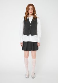 Gray pinstripe vest with silver buttons over a white shirt, paired with a matching pleated skirt and white lace knee-high socks. Silver flats.