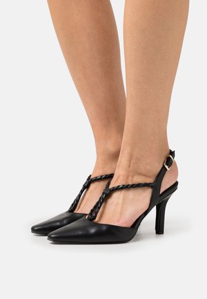 Schwarze High Heels mit spitzem Zeh, strukturiertem, rundem Riemen und Slingback-Design mit einer goldfarbigen Schnalle. Glatte Leder-Oberfläche.