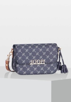 Bolso bandolera azul oscuro con patrón floral blanco, logo dorado de JOOP, correa marrón y borlas decorativas sobre una superficie clara.