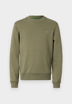 Sudadera verde oliva, mezcla de algodón, cuello redondo, puños y dobladillo acanalados, con pequeño logo bordado en el pecho. Textura suave.