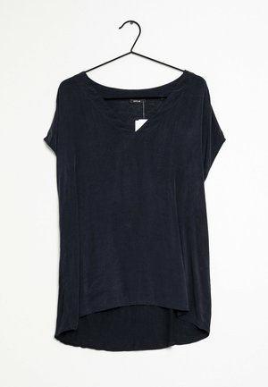 Schwarze Kurzarmbluse mit V-Ausschnitt und hohem-niedrigem Saum, aufgehängt an einem schwarzen Drahtbügel vor weißem Hintergrund.