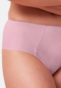 Mutande rosa chiaro con una superficie liscia, caratterizzate da una sezione decorata su un lato, che evidenzia un design senza cuciture e confortevole.