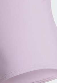 Svetlofialová elastická látka s hladkou textúrou, v ktorej sa nachádza jemný rebrovaný vzor a čisté švy pozdĺž lemu.