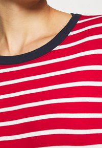 Rot-weißer gestreifter Baumwoll-T-Shirt mit einem marineblauen Rundhalsausschnitt. Besitzt eine glatte Textur und gleichmäßig verteilte horizontale Streifen.