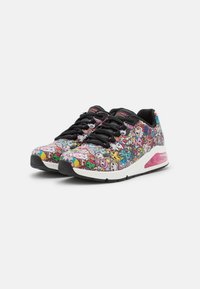 Sneaker mit einem mehrfarbigen Grafikdesign, das Comicfiguren zeigt. Schwarzes Obermaterial, rosa Akzente und eine sichtbare Luftpolsterung in der Sohle.