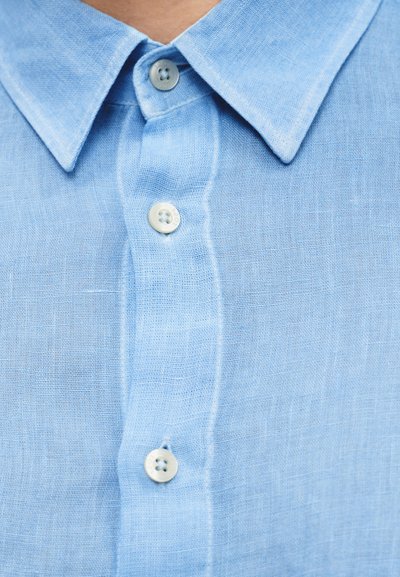 Φόρεμα από λινό σε γαλάζιο χρώμα με εμπρός κλείσιμο με κουμπιά, κλασικό γιακά και δύο ορατά κουμπιά στην πατιλέτα. Υφή υφάσματος.