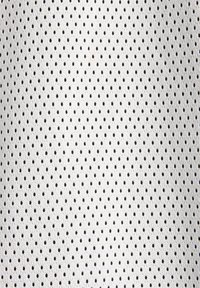 White mesh fabric featuring a pattern of evenly spaced black dots, with a breathable texture suitable for athletic wear or lining.