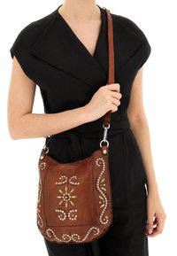 Borsa a tracolla in pelle marrone con motivo floreale in rilievo e borchie decorative. Ha una forma curva e una tracolla regolabile per il massimo comfort.